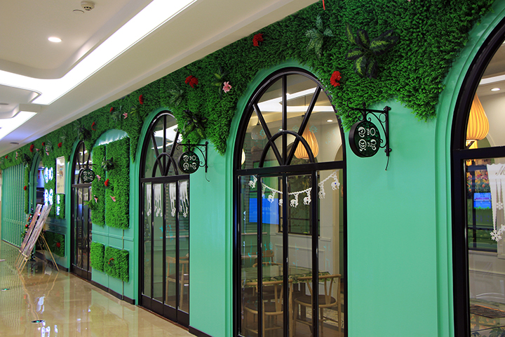 使用仿真植物墙装饰的餐饮店墙面
